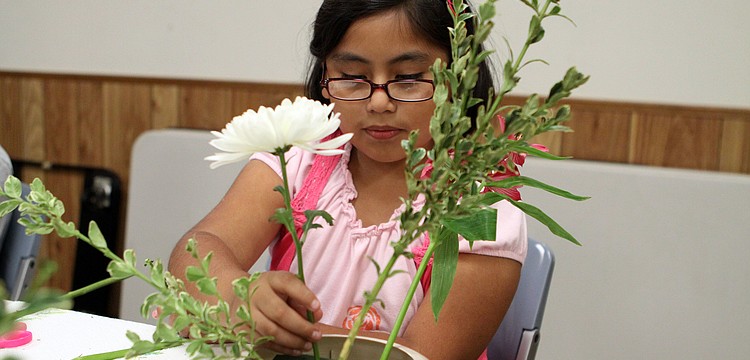 Melody Ramos, 8, works on properly placing her â€œhikaeâ€ into her arrangement.