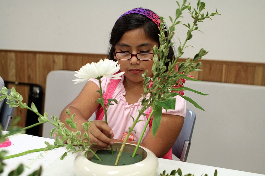Melody Ramos, 8, works on properly placing her â€œhikaeâ€ into her arrangement.