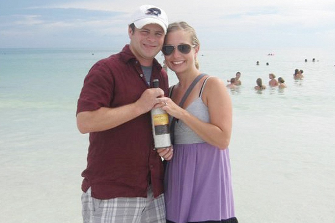 Chad and Katelyn Maggi show off a wine bottle with ChadÃ¢â‚¬â„¢s personalized proposal message. Courtesy photo.