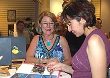 Artist Jean Cipriano, left, showed her work to guest Anna Polanco, right.