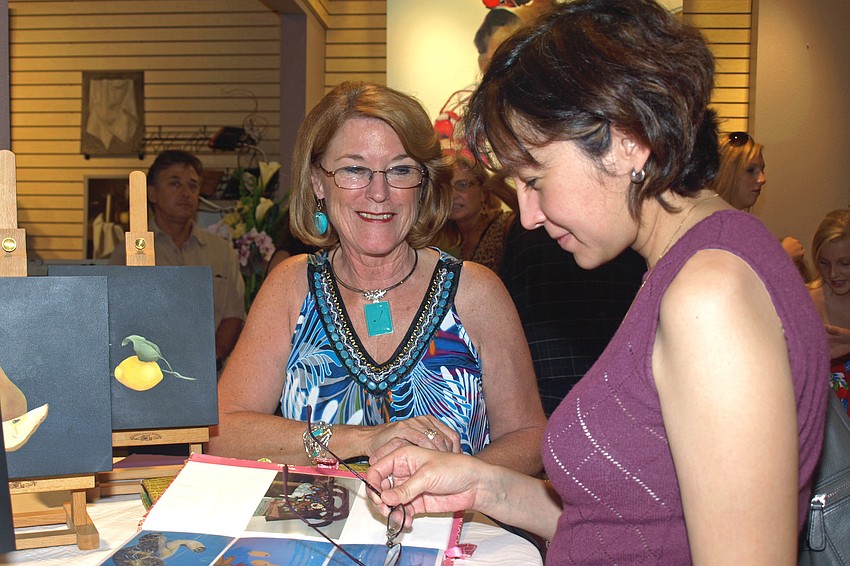 Artist Jean Cipriano, left, showed her work to guest Anna Polanco, right.