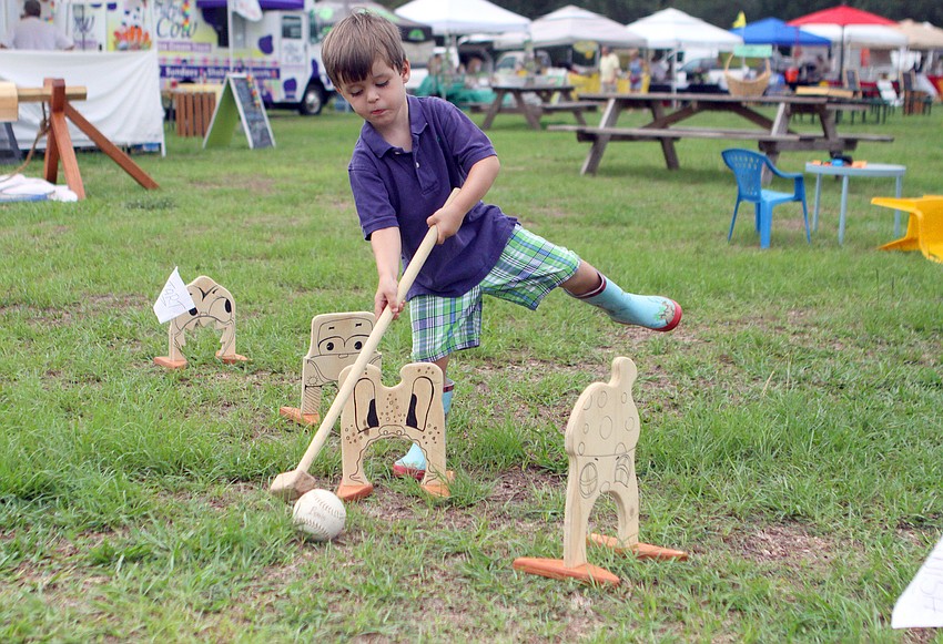 Dalton Burroughs, 3, tries to hit a ball through a wicket with a mallet, Wednesday, June 6.