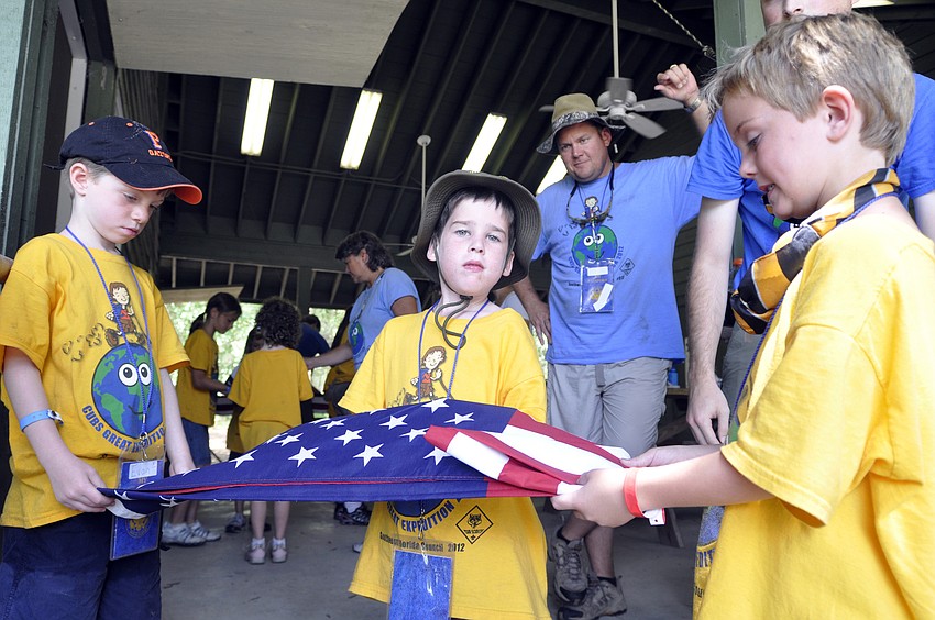 Six-year-olds Evan Fredd, Eric Brady and Conner Manrodt learned how to properly fold the flag.