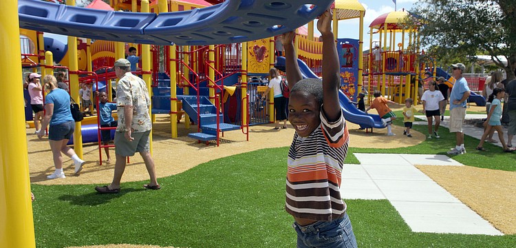 Shawn Mitchell, 8, spins around and around on one of the many fun pieces of playground equipment at the new, circus-themed playground at Payne Park.