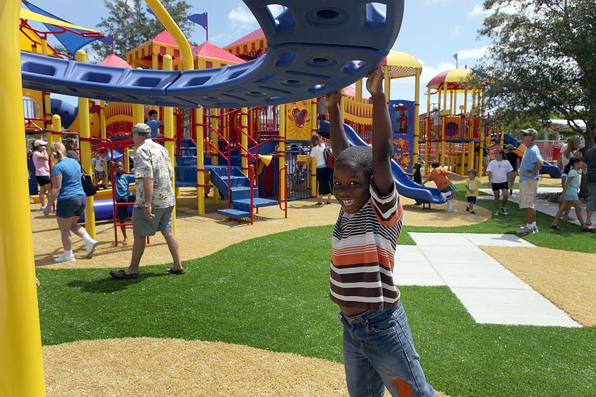 Shawn Mitchell, 8, spins around and around on one of the many fun pieces of playground equipment at the new, circus-themed playground at Payne Park.