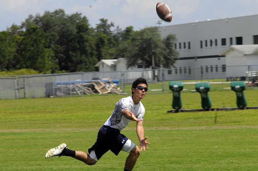 Fourteen-year-old Nate Minic reaches out for a pass during a wide receiver drill.