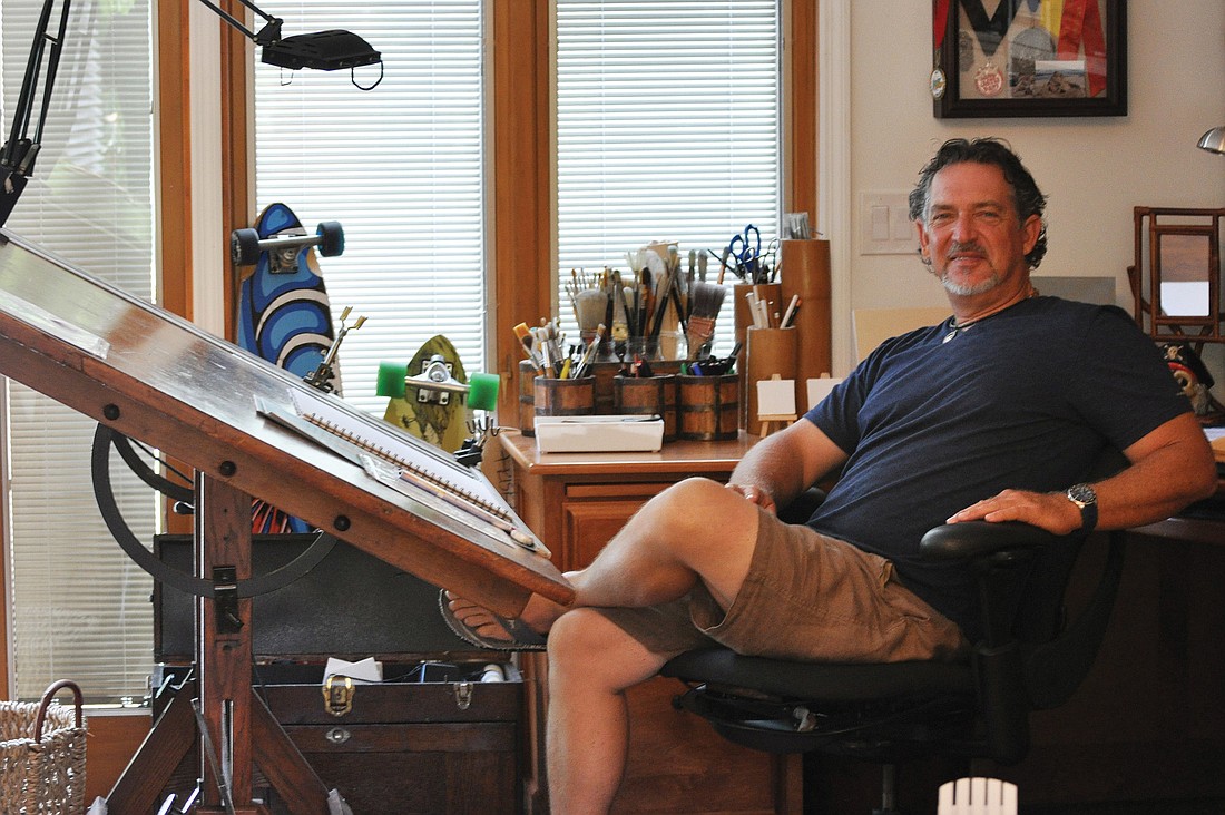 Brian Wigelsworth, shown here at the drafting table in his studio on Big Pass Lane, only draws plans for sand sculptures when working with a partner. On his own, Wigelsworth shapes his works by memory.