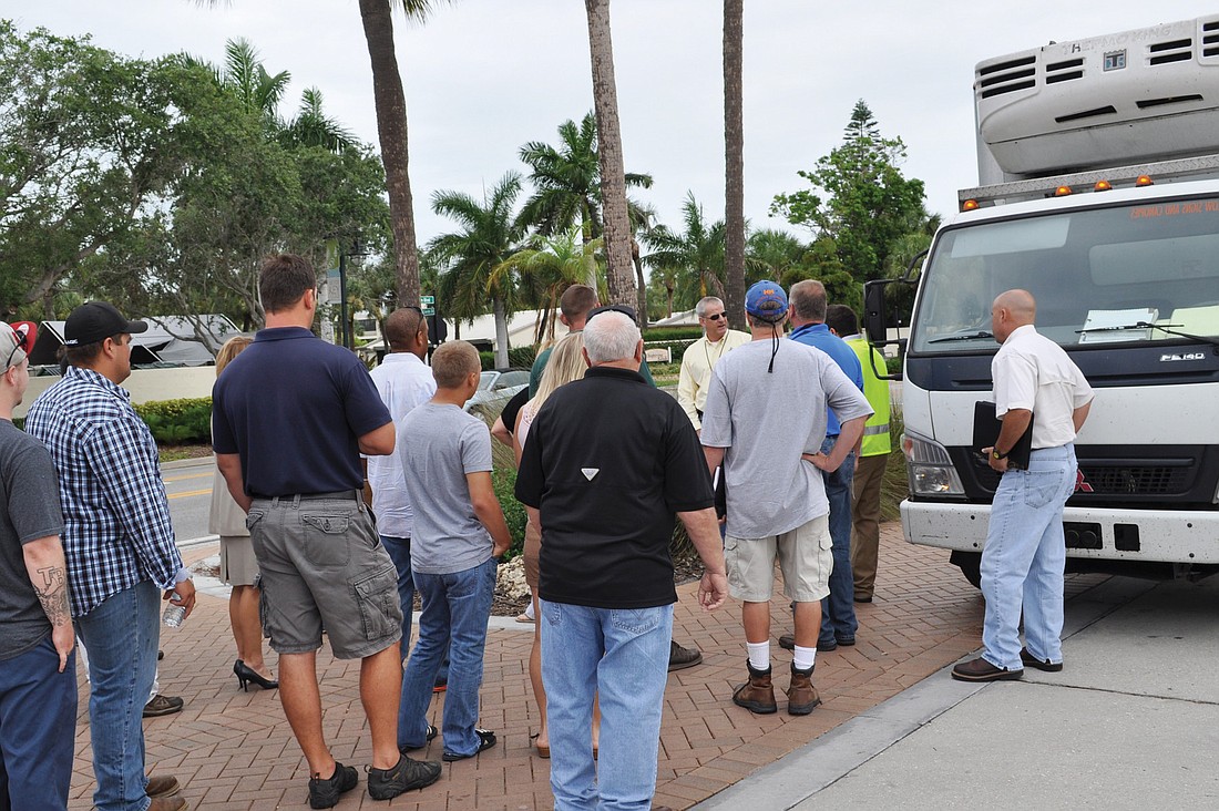 About 25 construction and lawn maintenance firm representatives follow Sarasota County Business Operations General Manager Tom Maroney during a tour of Siesta Key Village.