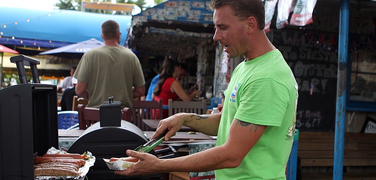 Douglas Jennings serves up a hot dog, Wednesday, July 4, at SKOB.