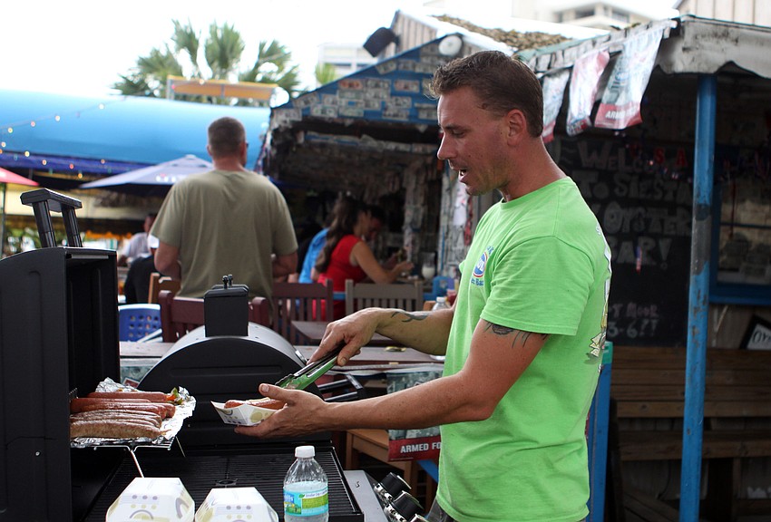Douglas Jennings serves up a hot dog, Wednesday, July 4, at SKOB.