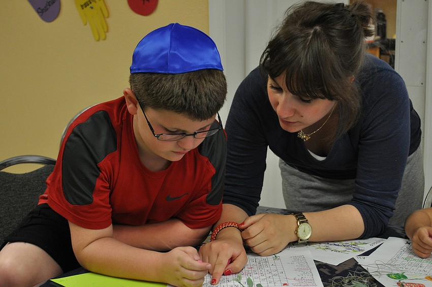 Joshua Braunstein, 7, got help with a word search from counselor Sarah Lurie.