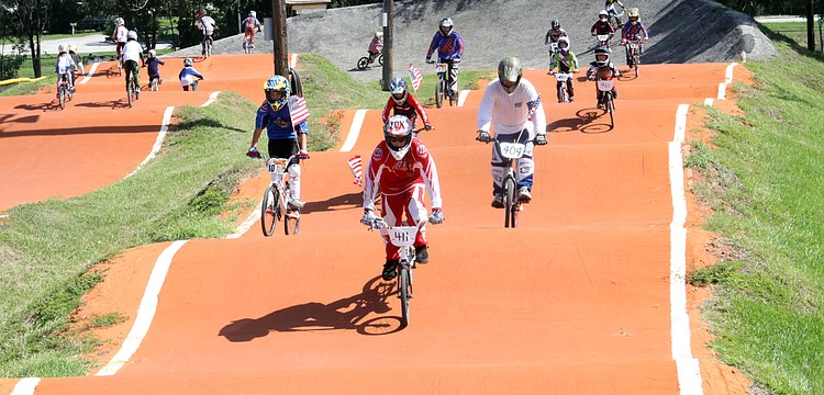 All the race participants rode around the course with American flags during the playing of the National Anthem, Saturday, July 7, at Sarasota BMX during Olympic Day.