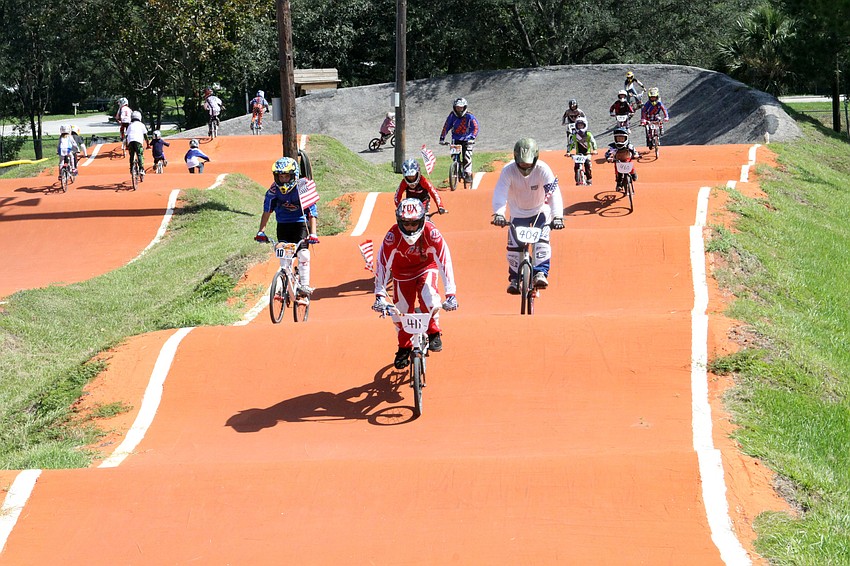 All the race participants rode around the course with American flags during the playing of the National Anthem, Saturday, July 7, at Sarasota BMX during Olympic Day.