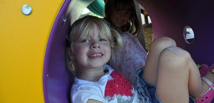 Annie Rinsema, front, and Amelia Jerome, behind, found a shady spot on the playground.