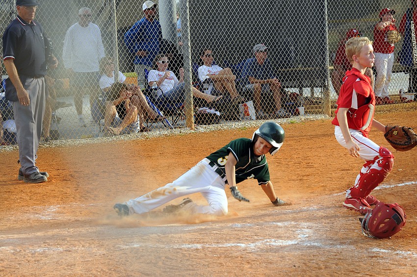 Wyatt Hollifield slides safely into home plate during Lakewood Ranch Little Leagueâ€™s 5-4 victory over Manatee West.