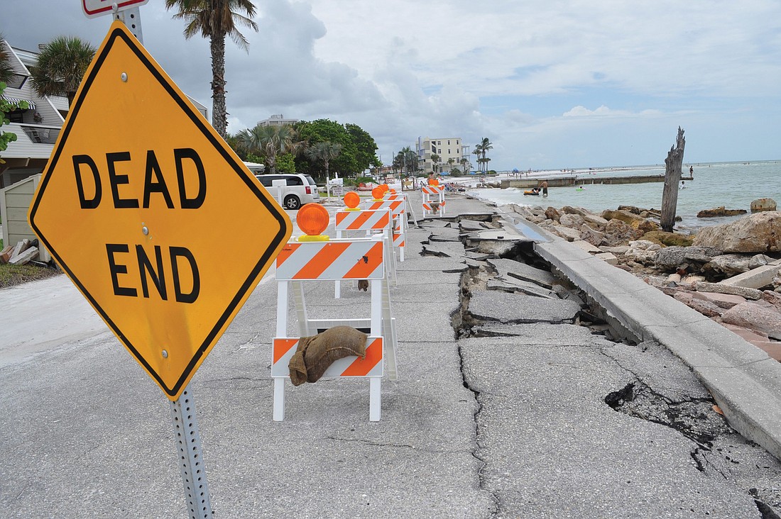 Sarasota County placed eight barricades secured by sand bags near the collapsed asphalt on Beach Road, which it plans to temporarily repair.