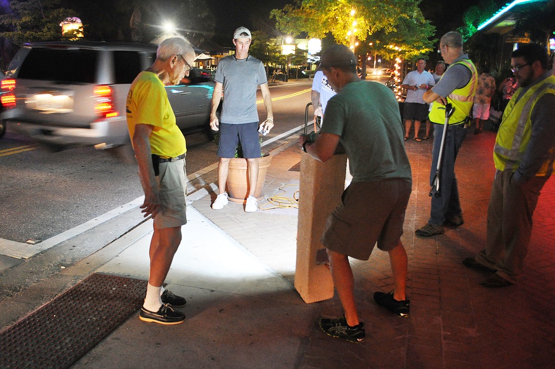 Siesta Key Association Vice President Peter van Roekens and Siesta Key Village Association President Russell Matthes stand in front of an LED bollard that could light Village crosswalks in the future.