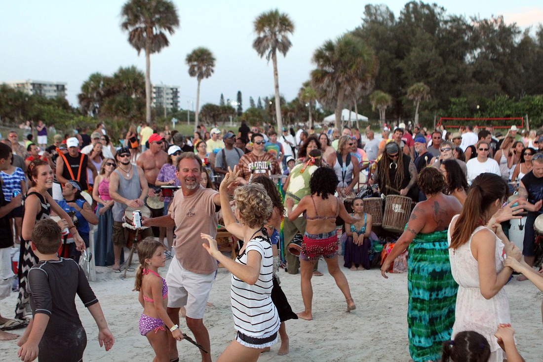 People have fun dancing to the beats played by the percussionists, Sunday, July 29, out on Siesta Key Public Beach.