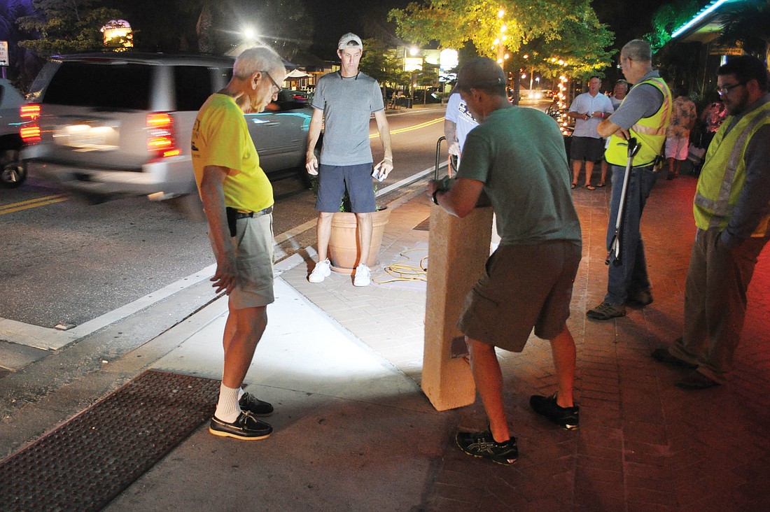 Sarasota County employees and Siesta Key residents, including Siesta Key Village Association President Russell Matthes, second from left, test specifications for crosswalk lighting in Siesta Key Village.