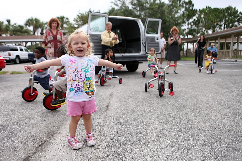 Rylee Wyant, 2, reacts to the van full of new tricycles, Tuesday, Aug. 7, at Pines of Sarasota.