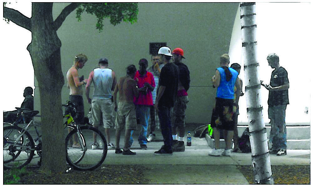 File photo. A group of homeless people gathers across the street from Five Points Park recently.