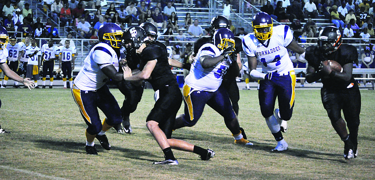 Sarasota High School cornerback Quincy Battie, right, rushes after a turnover from Booker High School's offense in the first regular season game Friday, Aug. 31. The Sailors bested the Tornadoes 51-6.
