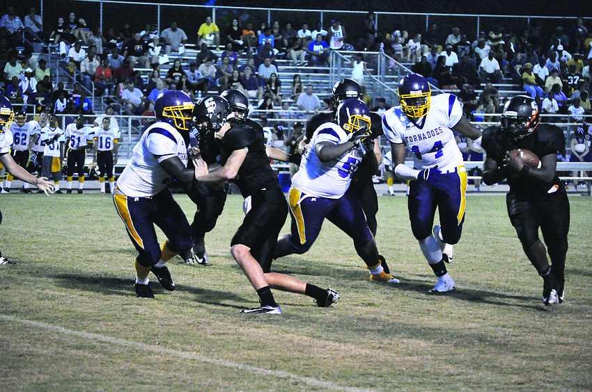 Sarasota High School cornerback Quincy Battie, right, rushes after a turnover from Booker High School's offense in the first regular season game Friday, Aug. 31. The Sailors bested the Tornadoes 51-6.