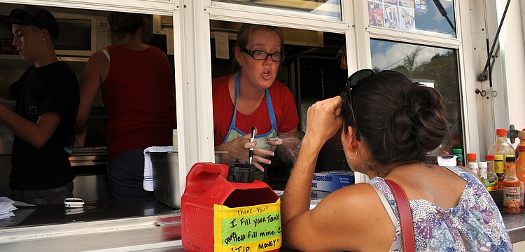 Michelle Jett takes an order from Tonya Saah from the Baja Boys Grill truck Tuesday, Sept. 11, opening day for Ringling Picnic.