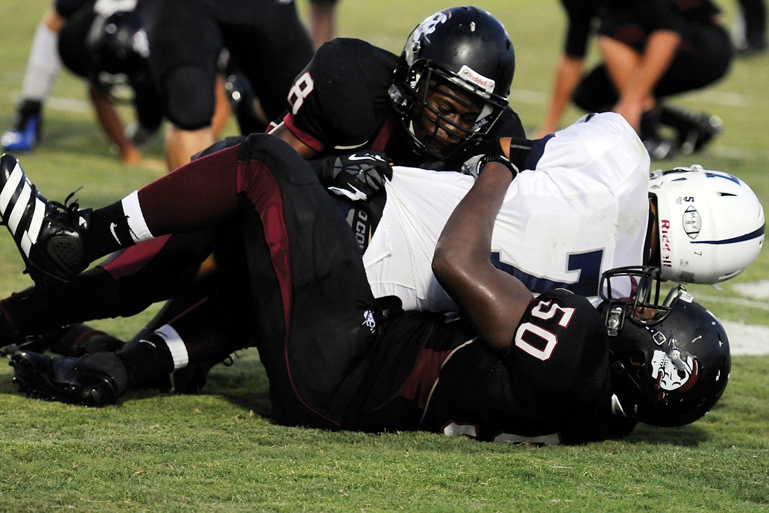 Jimiah Albritton and Curtis Govan tackle a North Port running back during the Pirates game versus the Bobcats Sept. 7.