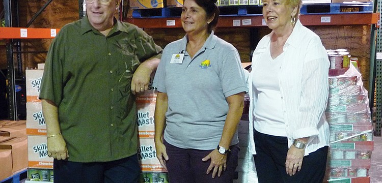 Rotary's Preston Olinger and Laurie Hagberg presented the donation to The Food Bank's Cindy Sloan, center. Courtesy photos.