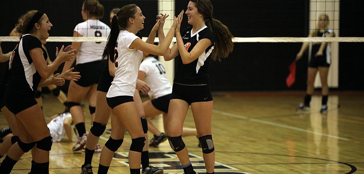 Jordan Brooks, No. 12, high fives her teammate CeCe Knight, No. 3, after making an impressive play Tuesday, Sept. 11 during the Cardinal Mooney versus Sarasota High School JV volleyball game at Sarasota High School.