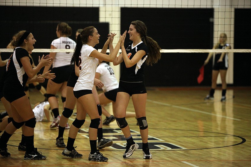 Jordan Brooks, No. 12, high fives her teammate CeCe Knight, No. 3, after making an impressive play Tuesday, Sept. 11 during the Cardinal Mooney versus Sarasota High School JV volleyball game at Sarasota High School.