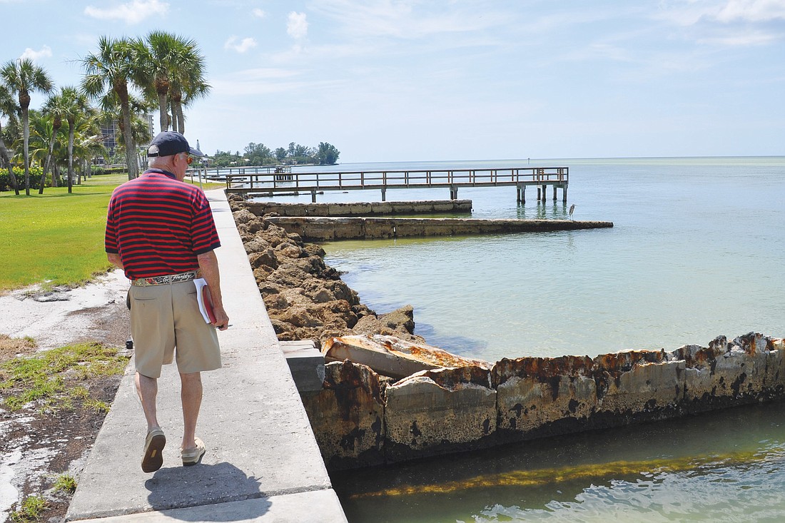 Roger Sandt surveys the seawall behind his Ocean Boulevard property, and points out a groin that crumbled during Tropical Storm Isaac.