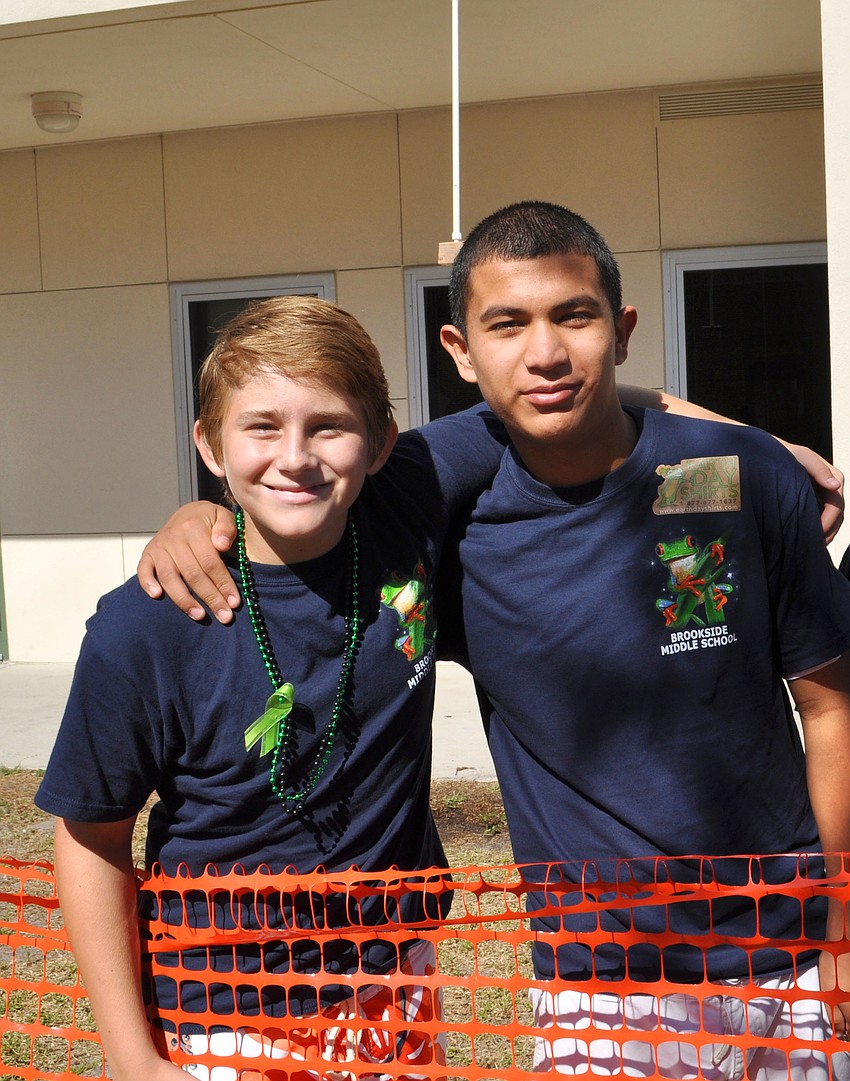 Jonathon Rabusin and Daniel De Los Santos stand near their five-gallon shower.