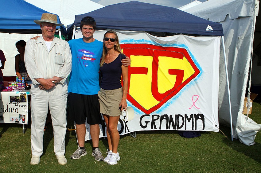 Ed Meyer, Riley Sheehan and Kristin Meyer pose in front of the banner they made for their team â€œFOR GRANDMAâ€ who passed away April, 12. â€œWe had really hoped she would be here for this event,â€ said Sheehan.