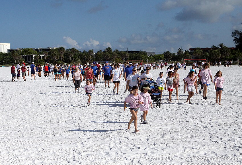 The teams head out onto the beach for the 3-mile walk.