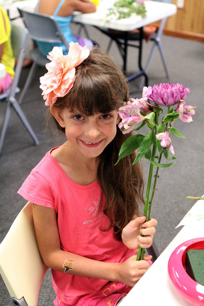 Alicia Ralsten, 8, holds up the flowers she chose to use for her Ikebana arrangement.