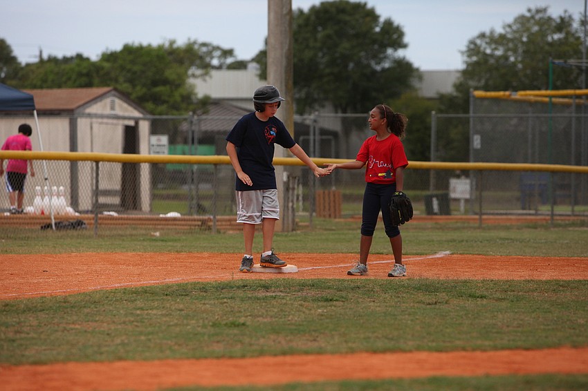 Aysha Mohamed gives Jake Peterman a low five for making an impressive run around the bases.