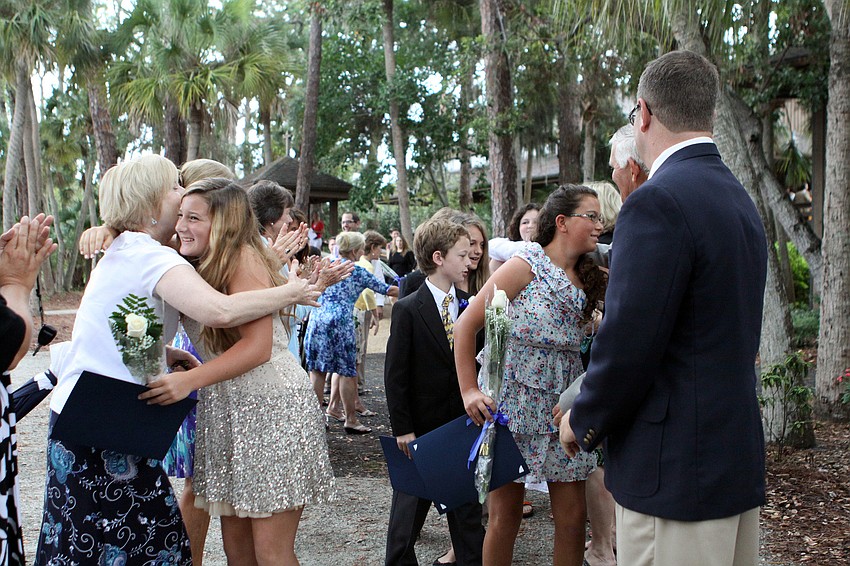 Students get hugs, handshakes, fist bumps and high fives from their teachers as they leave Siesta Key Chapel, Friday, June 1.