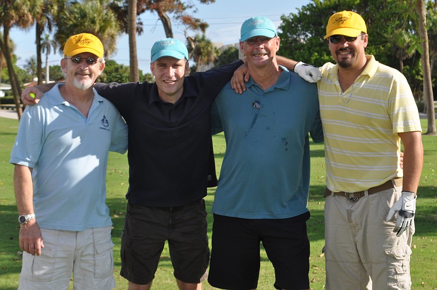 Colin Wilson, Eric Bell and Carter Miville stand-by as David Livengood putts