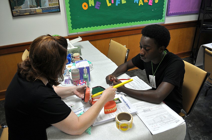 Dulci Morrell shows Jeremiah Martin good dental hygeine techniques.