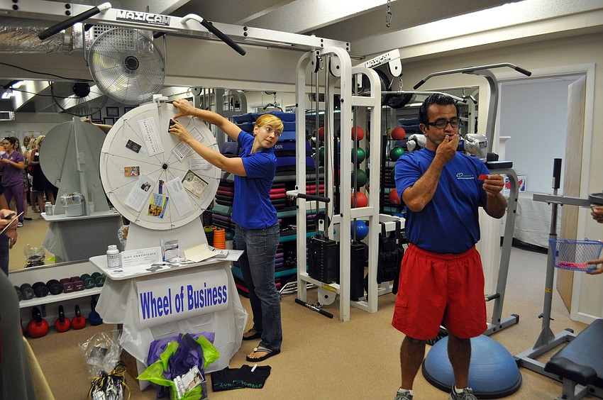 Kristen McGuigan spins the wheel as Felipe Cava addresses the crowd.