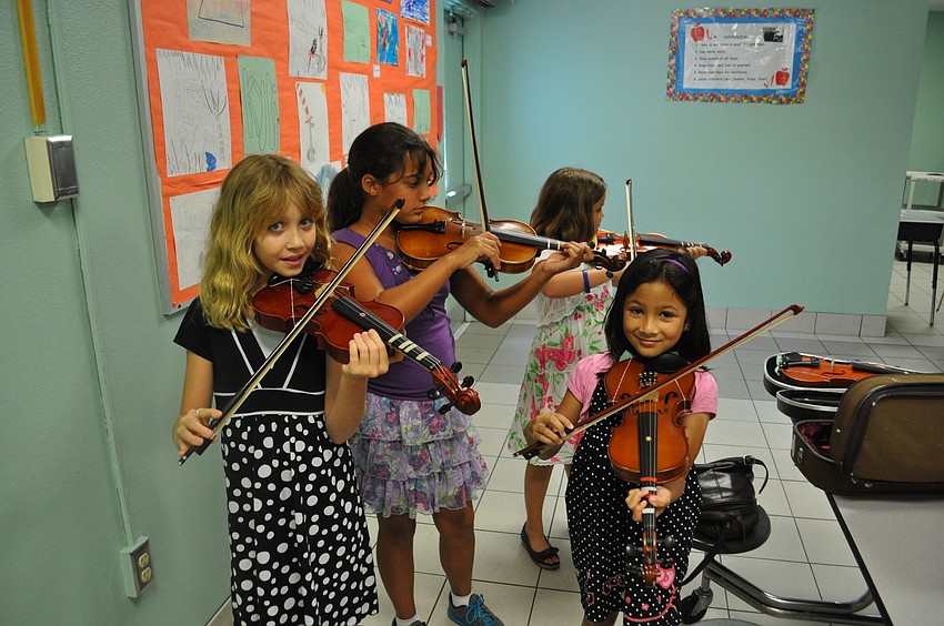 Students practice playing violin.