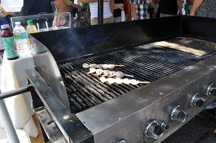 Shrimp kabobs cook on the grill.