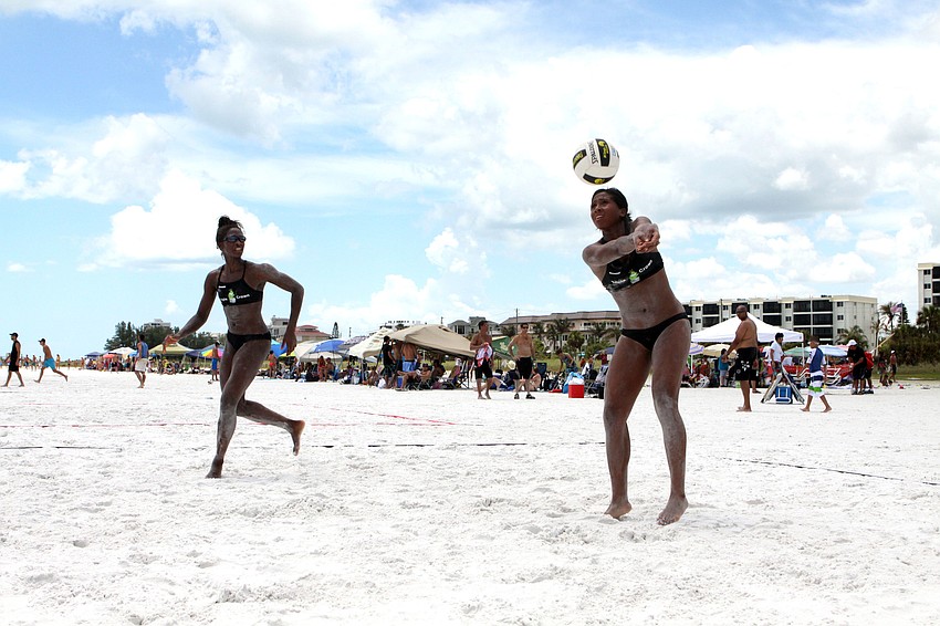 Larissa Witherspoon goes for the ball as her teammate, Chibuzo Aguocha, keeps close, Saturday, July 14, during the Dig the Beach tournament on Siesta Key Beach.