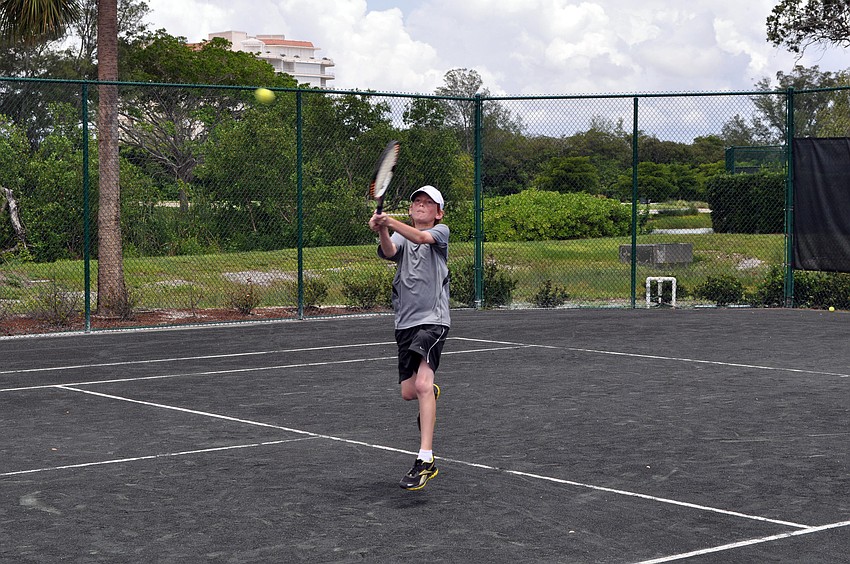 Benjamin Varah, 12, reaches up and over to get to the ball during his match against Stefan Stanczuk, 12, Monday afternoon.