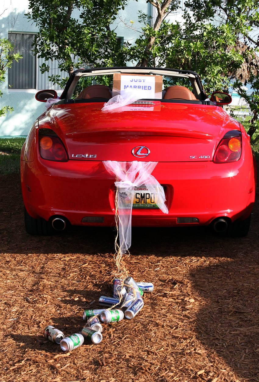 The red Lexus was decorated with a â€œJust Marriedâ€ sign along with a trail of beer cans tied to back bumper, Saturday, July 28.