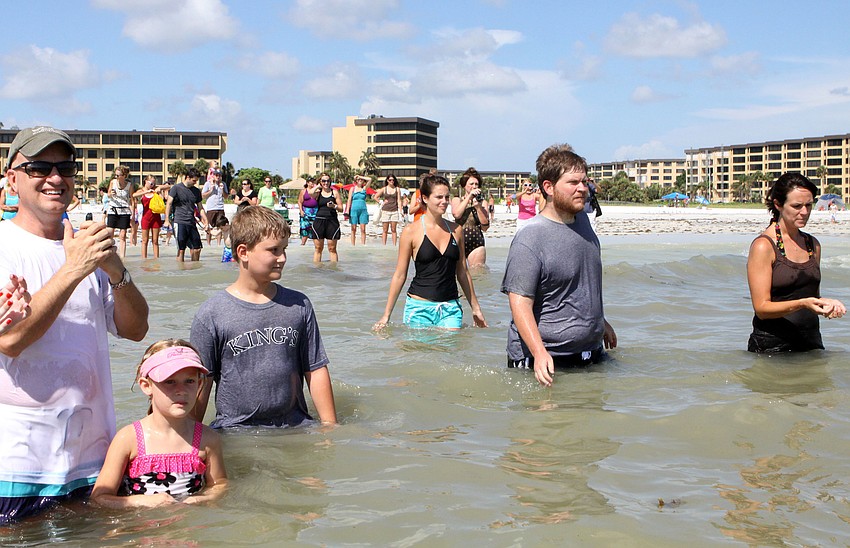 Family and friends clap and cheer after each baptism was performed, Sunday, July 30.
