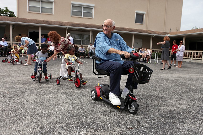 Bob Ireland leads the toddlers on his scooter in a game of â€œfollow the leaderâ€, Tuesday, Aug. 7.