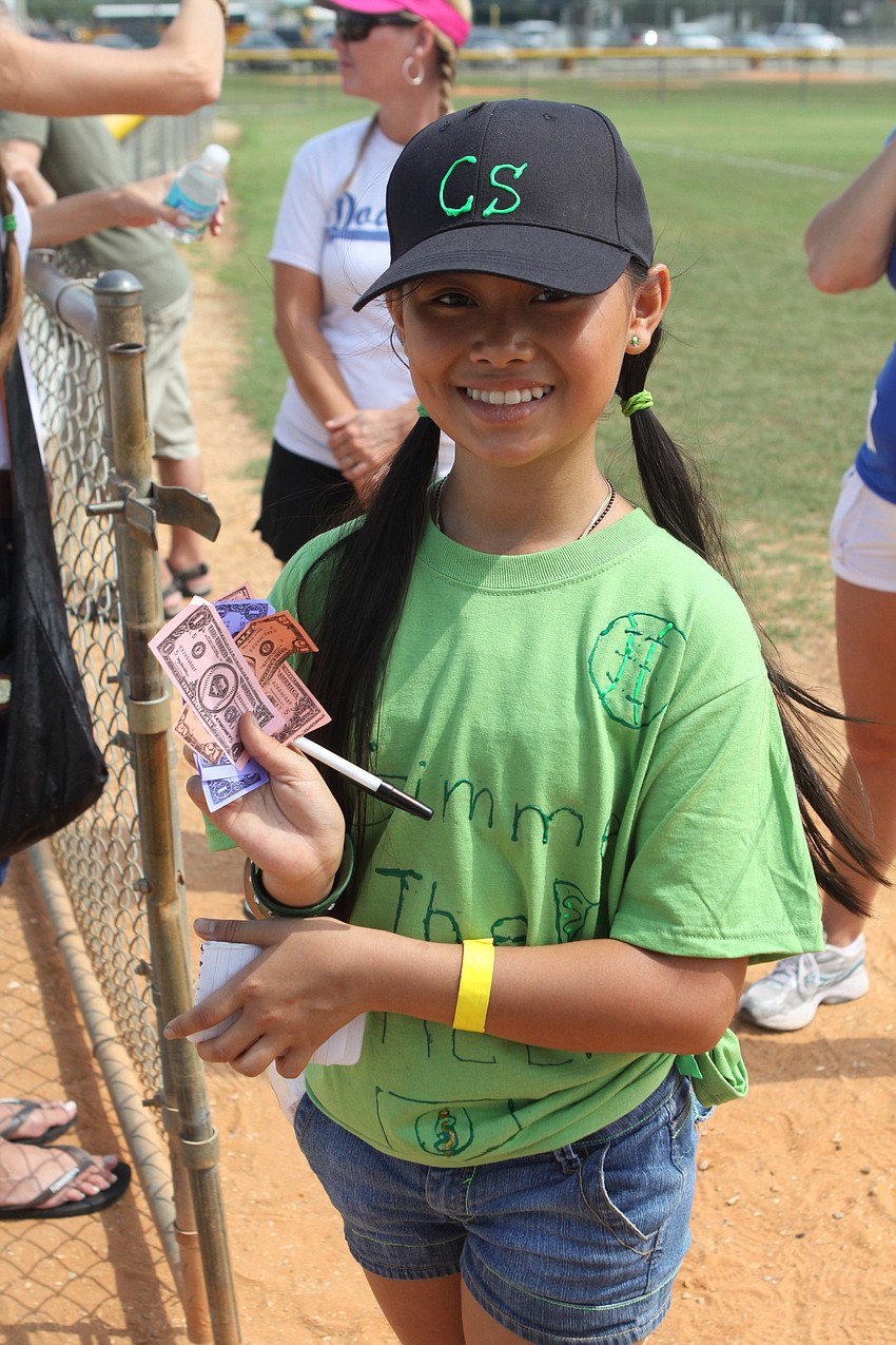 Katrina Lum shows off the baseball bucks she collects as a concession girl from the kids during Ashton Elementary's fifrth grade World Series games, Friday, April 29 at Twin Lakes.